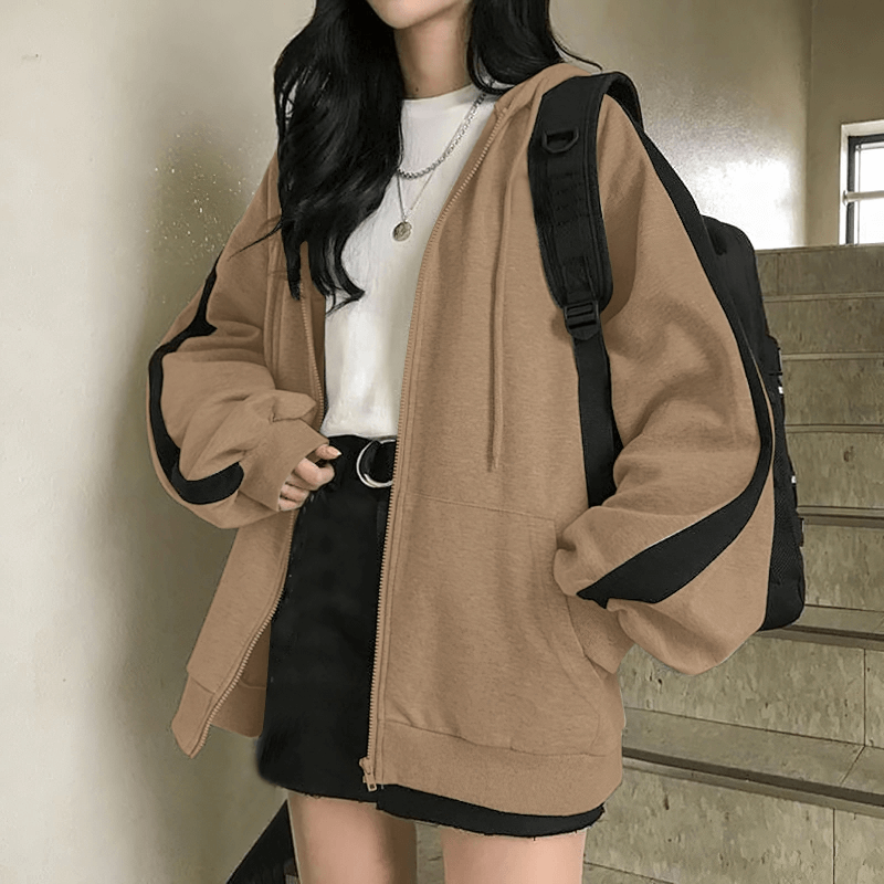 Woman wearing a stylish loose zipper hoodie, oversized hooded sweatshirt, ideal for casual occasions, featuring a durable blend fabric.